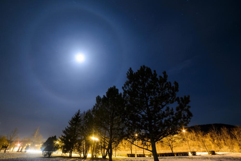 A halo elnevezésû fényjelenség látszik a Hold körül Salgótarjánból fotózva 2016. január 17-én. A gyűrű alakú fényjelenséget a 8-12 kilométer magasban elhelyezkedő felhőkben lévő jégkristályokon visszaverődött és megtört fénysugarak okozzák. 