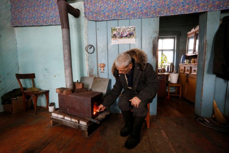 Baburin stokes furnace at his house in remote Siberian village of Mikhailovka
