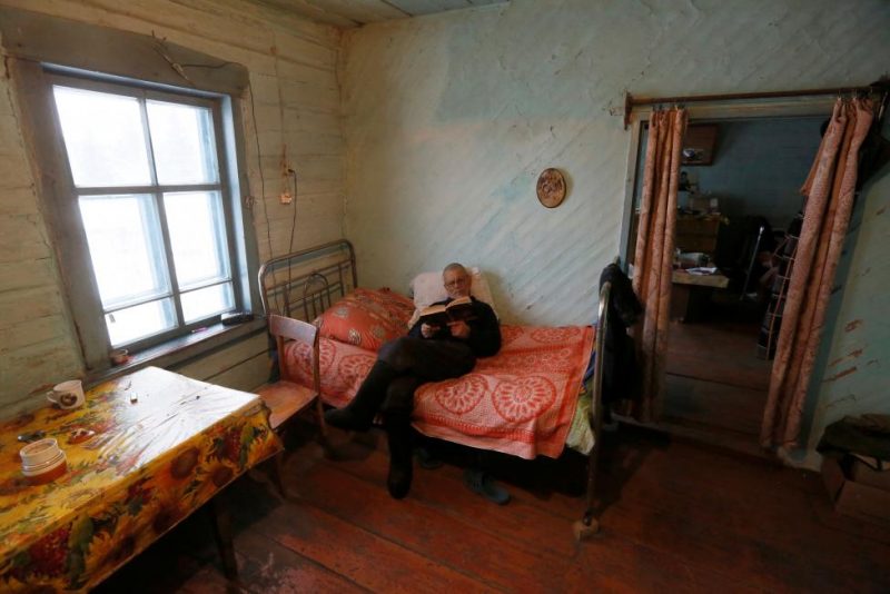 Baburin reads a book at his house in remote Siberian village of Mikhailovka