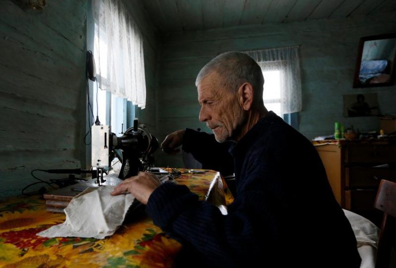 Baburin uses sewing machine at his house in remote Siberian village of Mikhailovka
